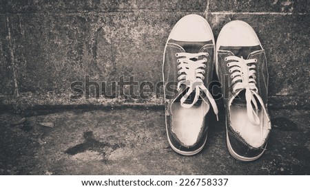 blue vintage shoes lean on old aged wall / concept \