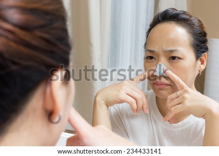 attractive asian beautiful woman caring her skin face front of mirror
