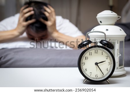 Asian man in bed suffering insomnia and sleep disorder thinking about his problem at night