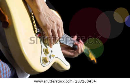guitarist hand playing electric guitar isolated on black & colorful bokeh