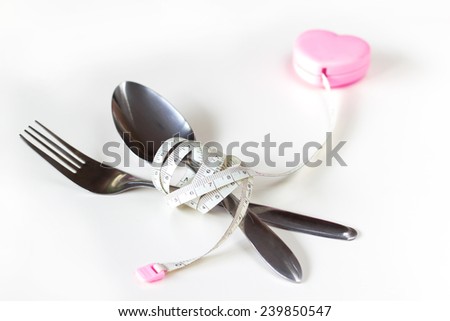 measurement tape strap spoon and fork for health concept = stop over eating before fat
