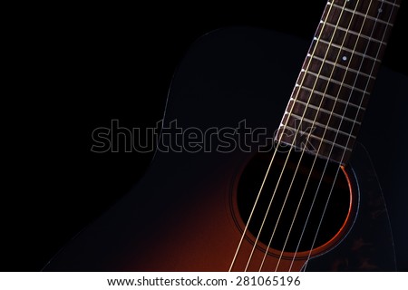 low key image showing part of sunburst acoustic guitar & beautiful rim light of six strings,frets and body shape , isolated on black + copy space for music concept background
