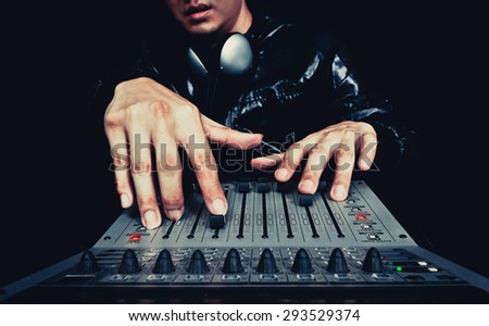 hand of asian handsome DJ, producer working on digital studio mixer for night club, radio , TV broadcasting background