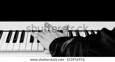 hands of male pianist / musician playing piano B&W isolated on black for music concept