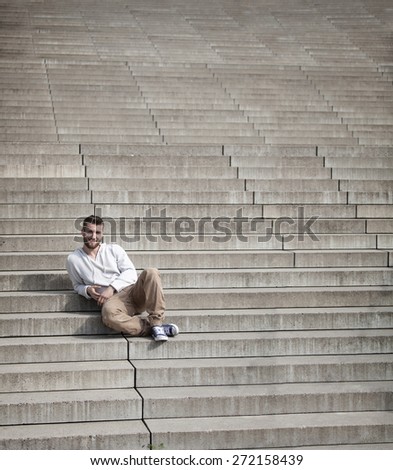 Attractive man is sitting on steps