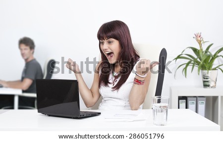 Beautiful business woman is screaming with happiness in the office