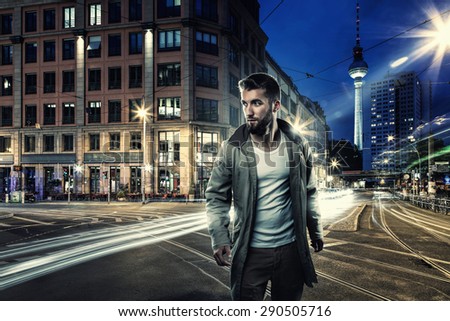 Attractive man walks through the streets of berlin at night