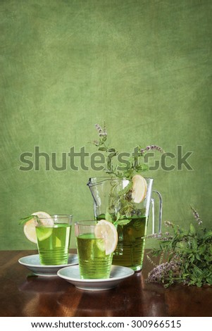 Homemade ice tea with lemon on a green background