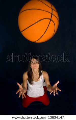 Pretty woman playing basketball against a blue background