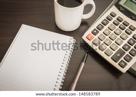 Closeup Coffee cup , Document file , pen , Calculator , notepad  on wooden table