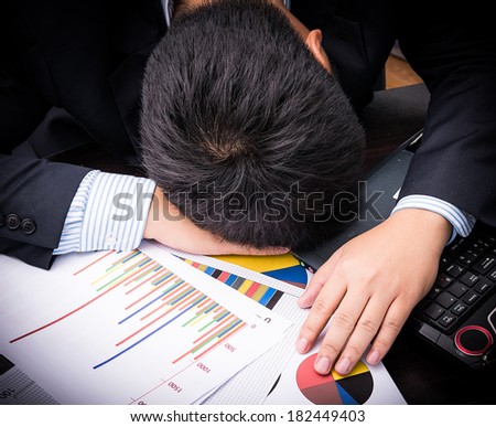 Exhausted and tired businessman sleeping in office at laptop
