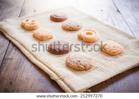 Cup of coffee and biscuit on sackcloth and wooden table