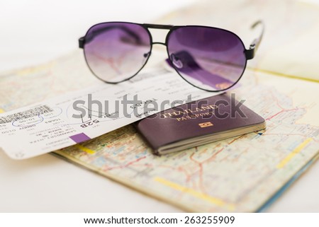 Passport on map and flight tickets, sunglasses. Focus at THAILAND Passport Book