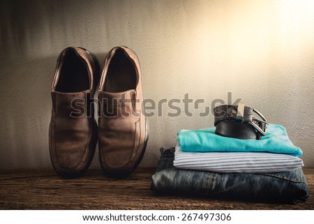 Still life with casual man on wooden tabletop against grunge wall. vintage tone