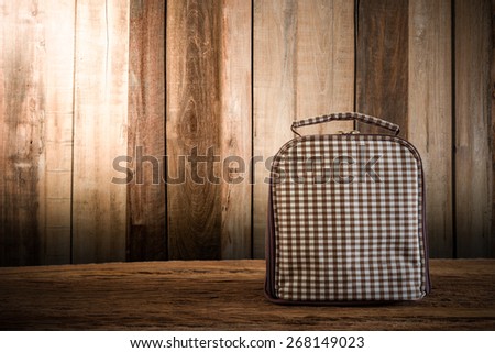 thermal bag on wooden tabletop against grunge wall. vintage tone