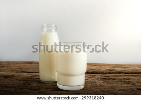 fresh milk in glass bottle and glass on wooden table