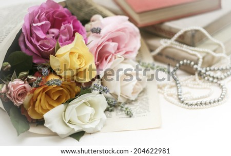 Wedding invitation. Roses with vintage book and pearl necklaces