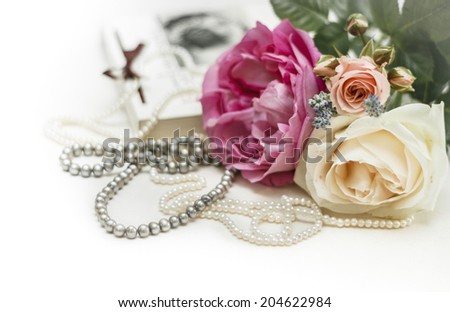 Wedding invitation. Roses with vintage book and pearl necklaces