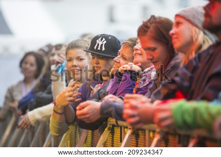 Traena, Norway - July 10 2014: audience during the concert of the Norwegian folk rock band Hekla Stalstrenga at the Traenafestival, music festival taking place on the small island of Traena.