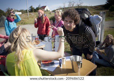 Traena, Norway - July 10 - 12 2014: at the campsite, funky caravan with young people painting, offering free waffle and coffee,Traenafestival, music festival taking place on the small island of Traena