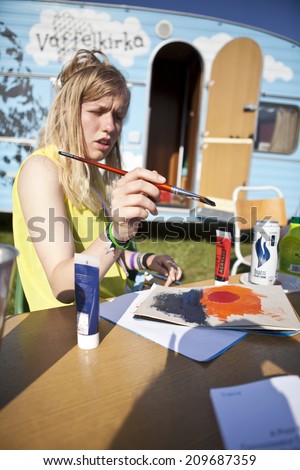 Traena, Norway - July 10 - 12 2014: at the campsite, funky caravan with young people painting, offering free waffle and coffee,Traenafestival, music festival taking place on the small island of Traena