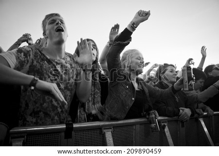 Traena, Norway - July 11 2014: people watching the concert of the Swedish pop-techno band Den Svenska Bjornstammen at the Traenafestival, music festival taking place on the small island of Traena