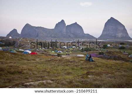 Traena, Norway - July 11 2014: at Traenafestival, music festival taking place on the small island of Traena, view over the island and the campsite with the mountains of Sana Island in the background