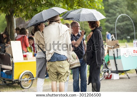 Amsterdam, The Netherlands - July, 5 2015: visitors walking under the rain during Amsterdam Roots Open Air, a cultural festival held in Park Frankendael on 05/07/2015