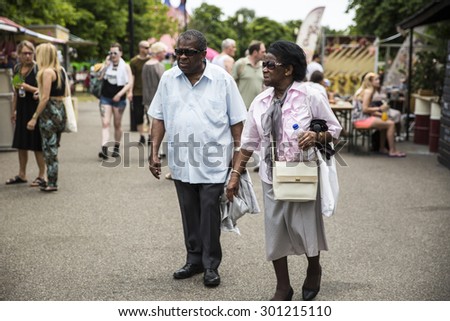 Amsterdam, The Netherlands - July, 5 2015: old black man and woman walking around during Amsterdam Roots Open Air, a cultural festival held in Park Frankendael on 05/07/2015