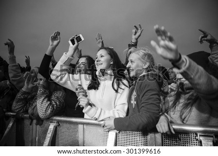 Traena, Norway - July 9 2015: fans cheering with arms up at concert of Norwegian rock band OnklP & De Fjerne Slektningene at Traenafestival, music festival taking place on the small island of Traena