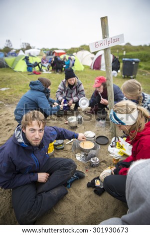 Traena, Norway - July 10 2015: group of friends cooking their diner at the campsite of Traenafestival, music festival taking place on the small island of Traena