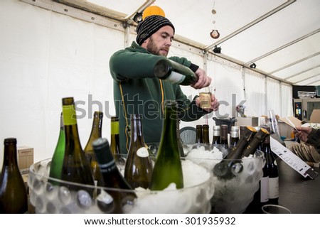Traena, Norway - July 10 2015: wine bar with waiter serving a glass at Traenafestival, music festival taking place on the small island of Traena
