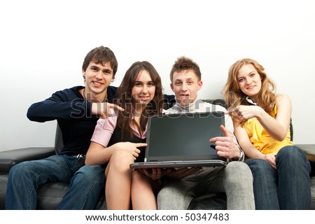 Group of students with the laptop sitting on a sofa
