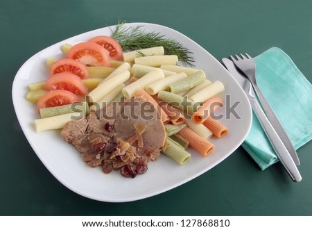 roasted pork meat with vegetable and pasta tubes as dinner or lunch meal
