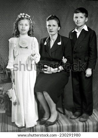 JASLO,POLAND - CIRCA 1960 : vintage photo of vintage photo of girl receiving First Holy Communion with Mother and brother