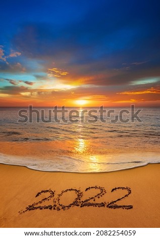 2022 happy New Year coming concept. Handwriting on the beach.
