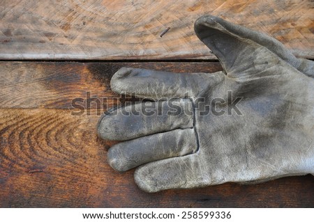 Old safety gloves on wooden background, Gloves on dirty works.