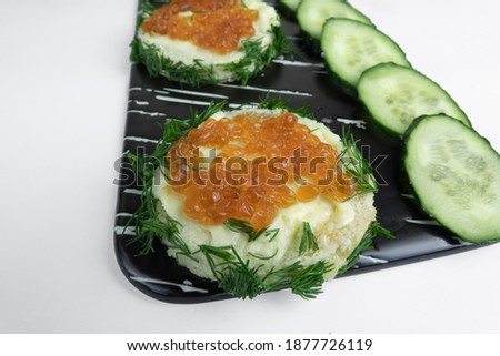 Kanapes with butter and red caviar, and sliced cucumber. Stock fotó © 