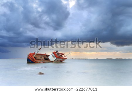 sinking boat in the sea with rain cloud