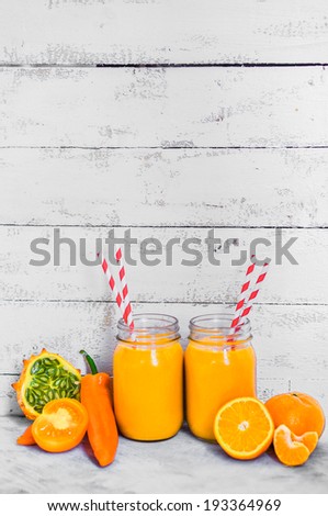 Orange smoothie on rustic background