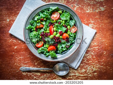 Kale and edamame salad on rustic background