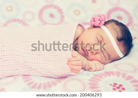Cute sleeping baby girl wrapped in blanket