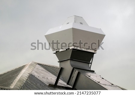 Kitchen exhaust extractor vent on the rooftop of a luxury resort hotel on a cloudy day. Сток-фото © 