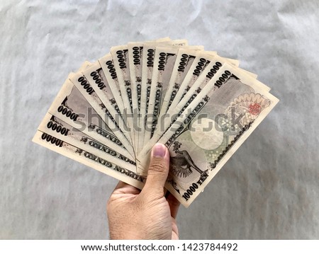 Money currency pile of japanese banknotes 10 000 yen on plain