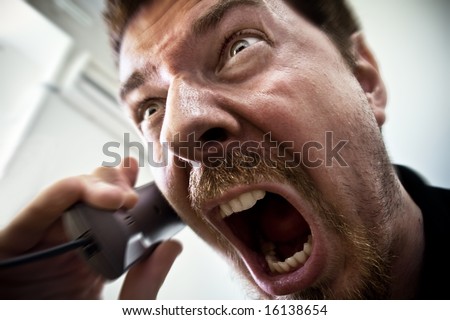 Extreme angry man shouting at the phone