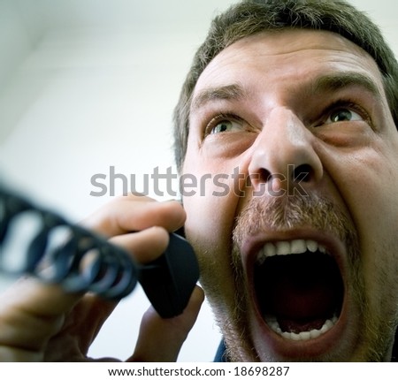 Portrait of angry stressed businessman screaming at the phone