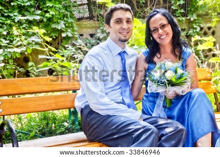 Happy married couple sitting on park bench