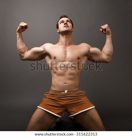Athletic guy showing his muscles - winner victory concept