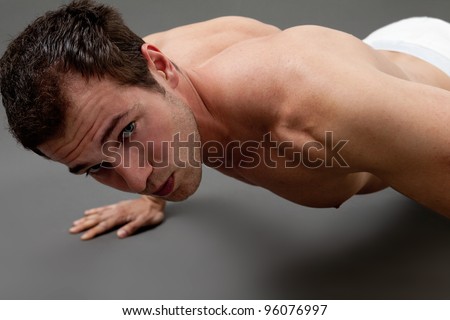 Fitness concept - sexy muscular man doing push-ups