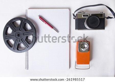 Overhead shot of a photographers workspace. A vintage film camera, film, negatives and the equipment